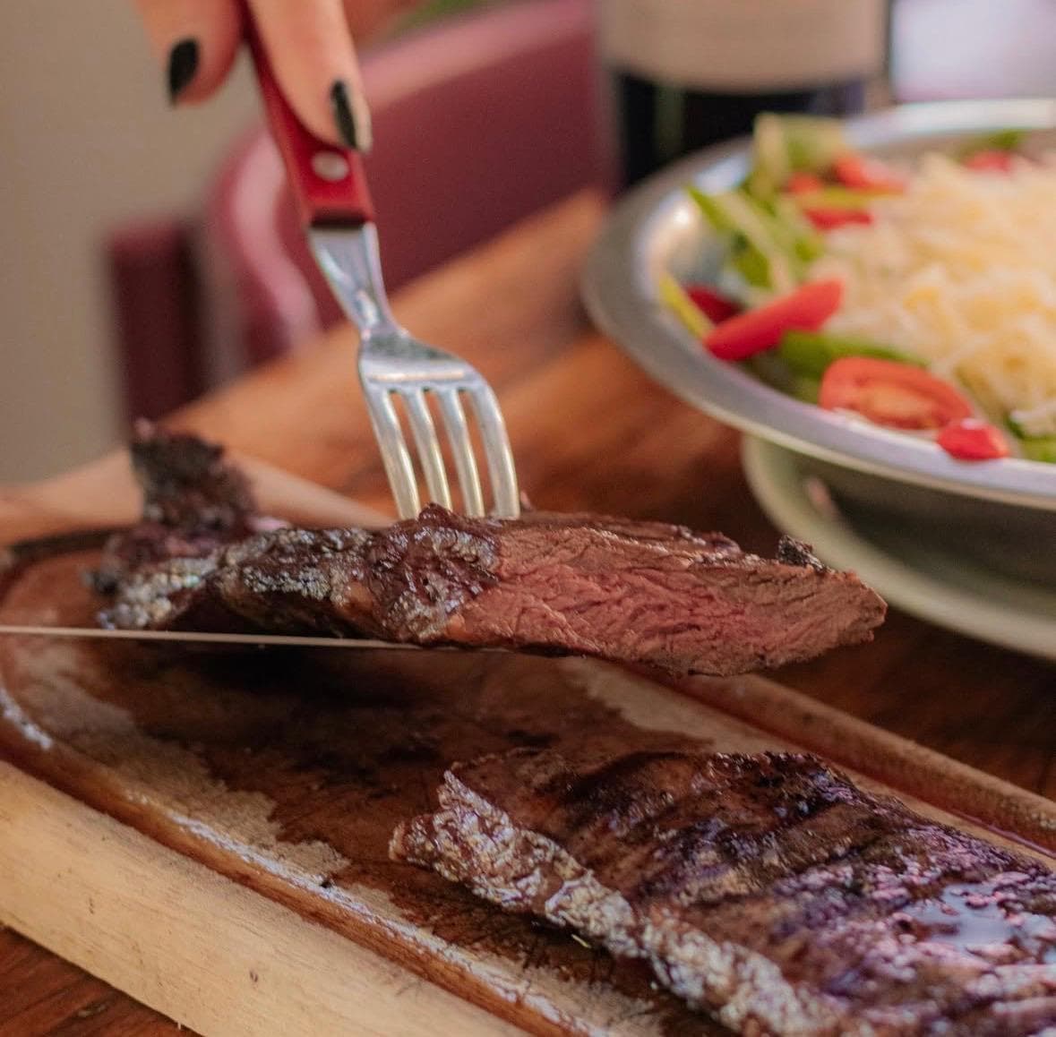 Entraña a la parrilla cortada sobre tabla de madera
